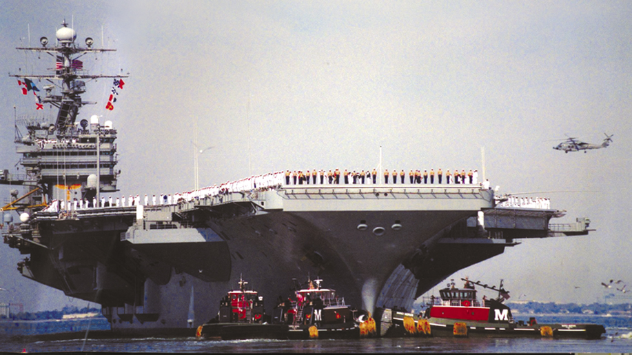 Two of the most modern Moran tugs guide the U.S.S. Roosevelt from Norfolk harbor following September 11, 2001.