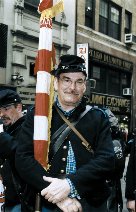 <em>During the Parade, Stephan O'Neill removes his eyeglasses, which are not authentic Civil War era. Carrying the American flag, he marches blind, he says.</em>