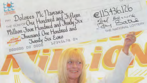 Dolores McNamara holds her bumper check aloft.