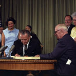 President Lyndon B. Johnson signing the Medicare bill, July 30, 1965.