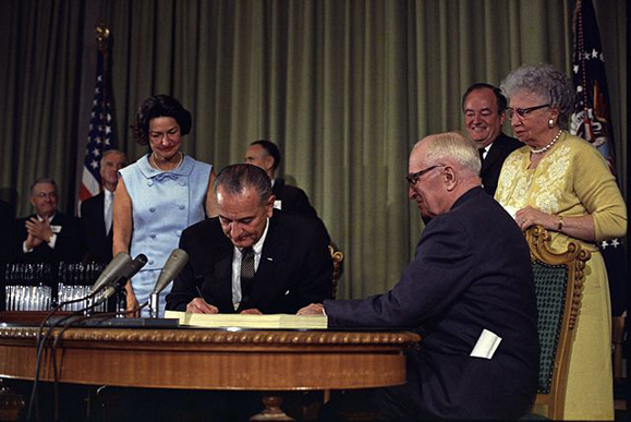 President Lyndon B. Johnson signing the Medicare bill, July 30, 1965.