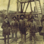 Jim Burke on refinery site with his felloe workers. He is the one on the right wearing the derby – the hard hat of his day.