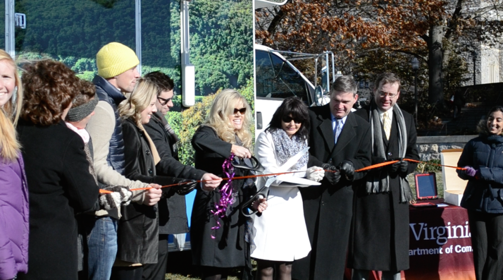 Clinical Director Paula Meade and Executive Director Teresa Gardner (with scissors) cutting the ribbon on their new Health Wagon. (Photo courtesy of the author)