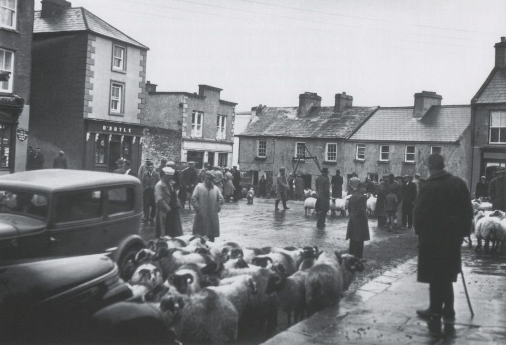 Sheep fair on Main Street in Newport, Co. Mayo. Many of the buildings can still be identified today.