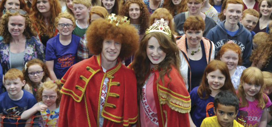 Newly crowned Redhead King and Queen, Alan Reidy and Grainne Keena, pose with a crowd full of red heads at the Irish Redhead Convention, which celebrates everything to do with red hair held in the village of Crosshaven on August 22, 2015 in Cork.