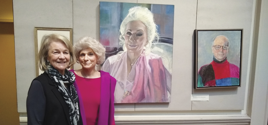 The artist Louise Peabody and singer Judy Collins pose in front of Peabody’s portrait of Collins at the Century Club.