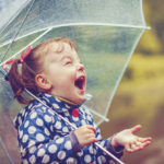 A little girl enjoys the rainfall.