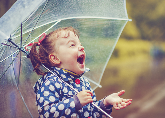 A little girl enjoys the rainfall.