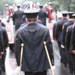 An injured fireman joins a comrade's funeral in Queens, New York; Photo - Peter Foley.