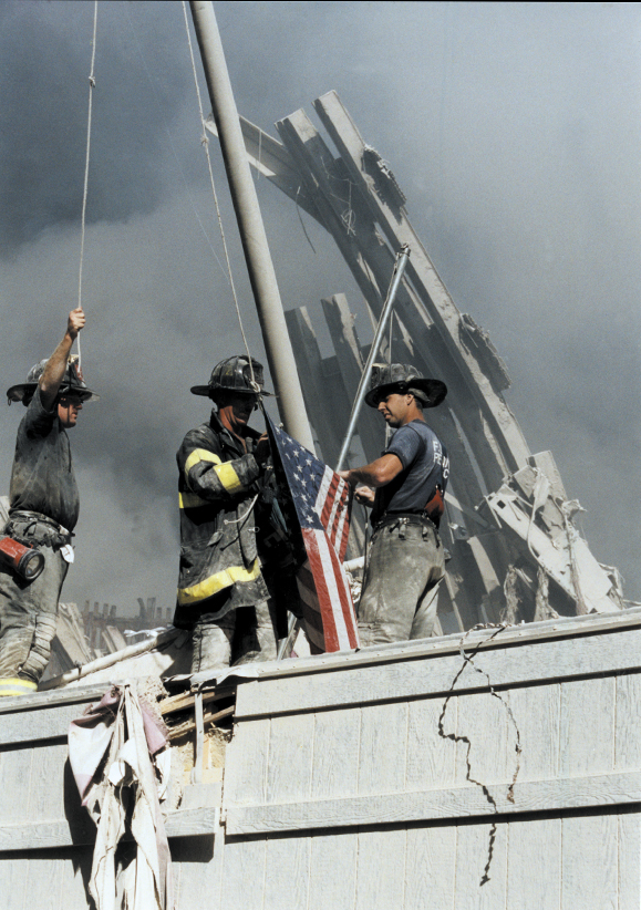 Firefighters raise the flag at Ground Zero following the 9/11 attacks.