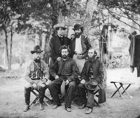 Photo of Irish Brigade chaplains in camp at Harrison's Landing, VA. itting from left to right: Captain Clooney, Eighty-eighth New York, Father Dillon, Chaplain of the Sixty-third New York, and Father Corby, Chaplain of the Eighty-eighth New York. Standing from left to right: Visiting priest and Colonel Patrick Kelly, Eighty-eighth New York.