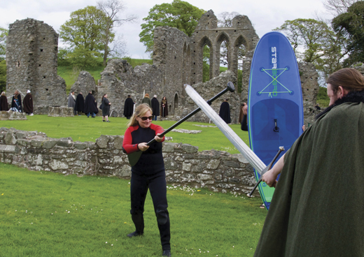 Pam brandishing her paddle, breaks into mock swordplay with a Game of Thrones fan at Inch Abbey.