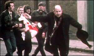 Father Edward Daly waving a blood-stained white handkerchief while trying to escort the mortally wounded John "Jackie" Duddy to safety, on Bloody Sunday, January 30, 1972.