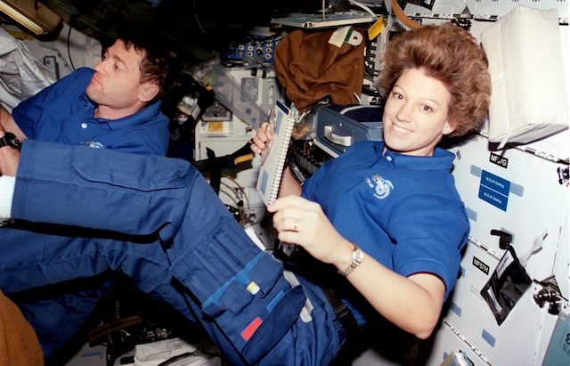 Astronauts Eileen M. Collins, mission commander; and Jeffrey S. Ashby, pilot, peruse checklists on Columbia's mid-deck. (Photo:NASA).