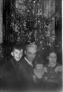 Jimmy, Eileen, and Joan with their dad, "Joe" in front of one of their tall Christmas trees in 1948.