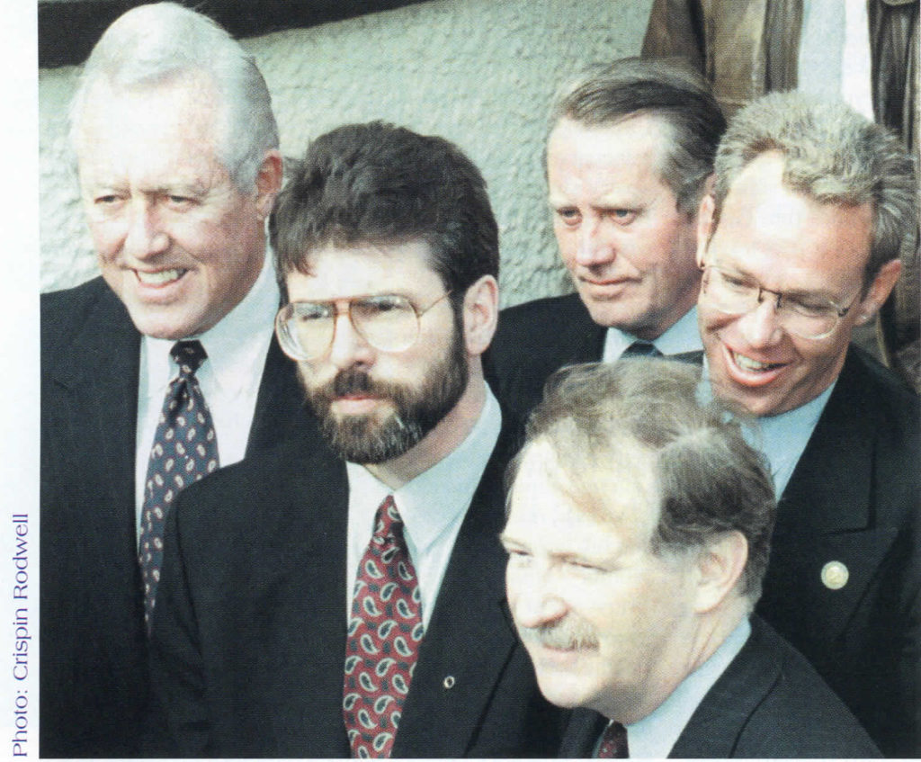Standing in the shadows: At Sinn Féin headquarters (left to right) Chairman of Mutual of America Bill Flynn, Sinn Féin leader Gerry Adams, Chuck Feeney, Congressman Bruce Morrison, and Irish American Labor Coalition leader Bill Leenihan. Belfast, December 17, 1997.
