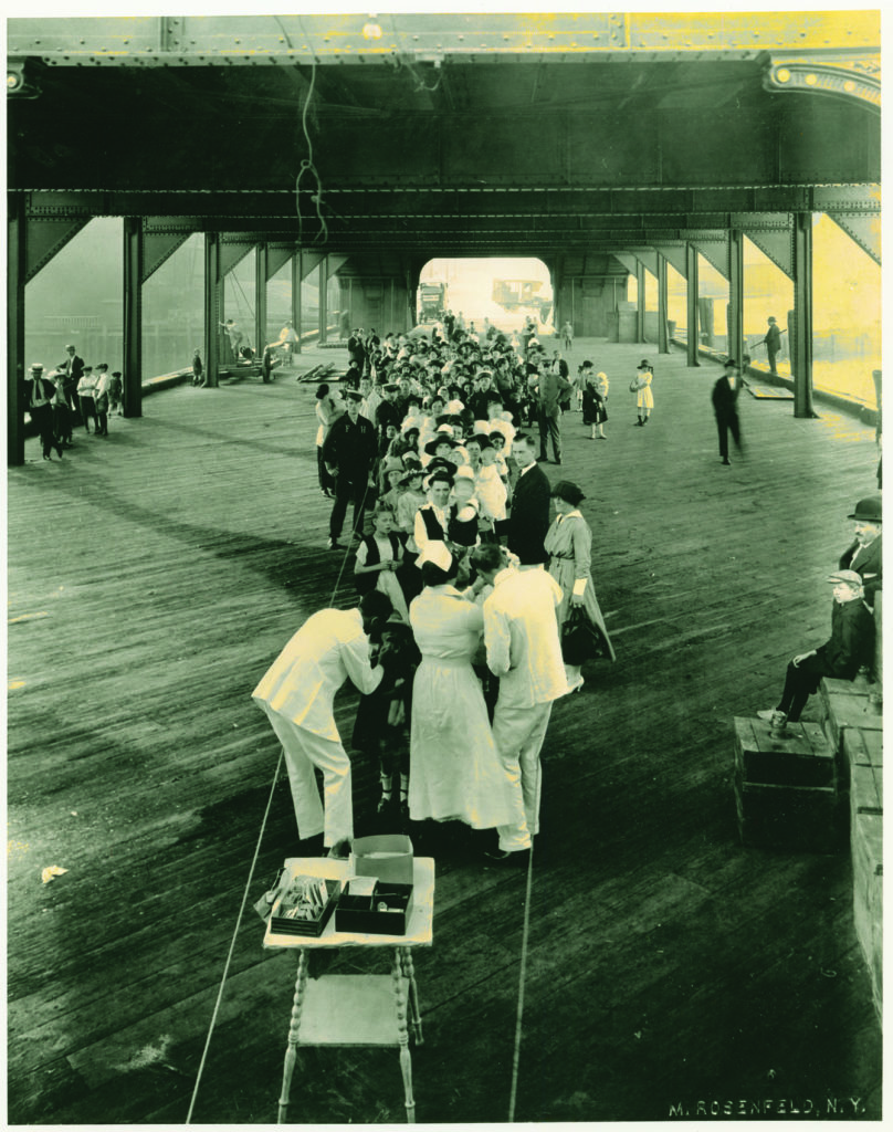 Photo from 1914. Patients waiting to board The Floating Hospital after having received a medical exam and screening for infectious diseases.