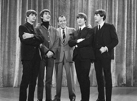 The Beatles with Ed Sullivan from their first appearance on Sullivan's US variety television program in February 1964. From left: Ringo Starr, George Harrison, Ed Sullivan, John Lennon, Paul McCartney. Photo CBS Television, Wikipedia.